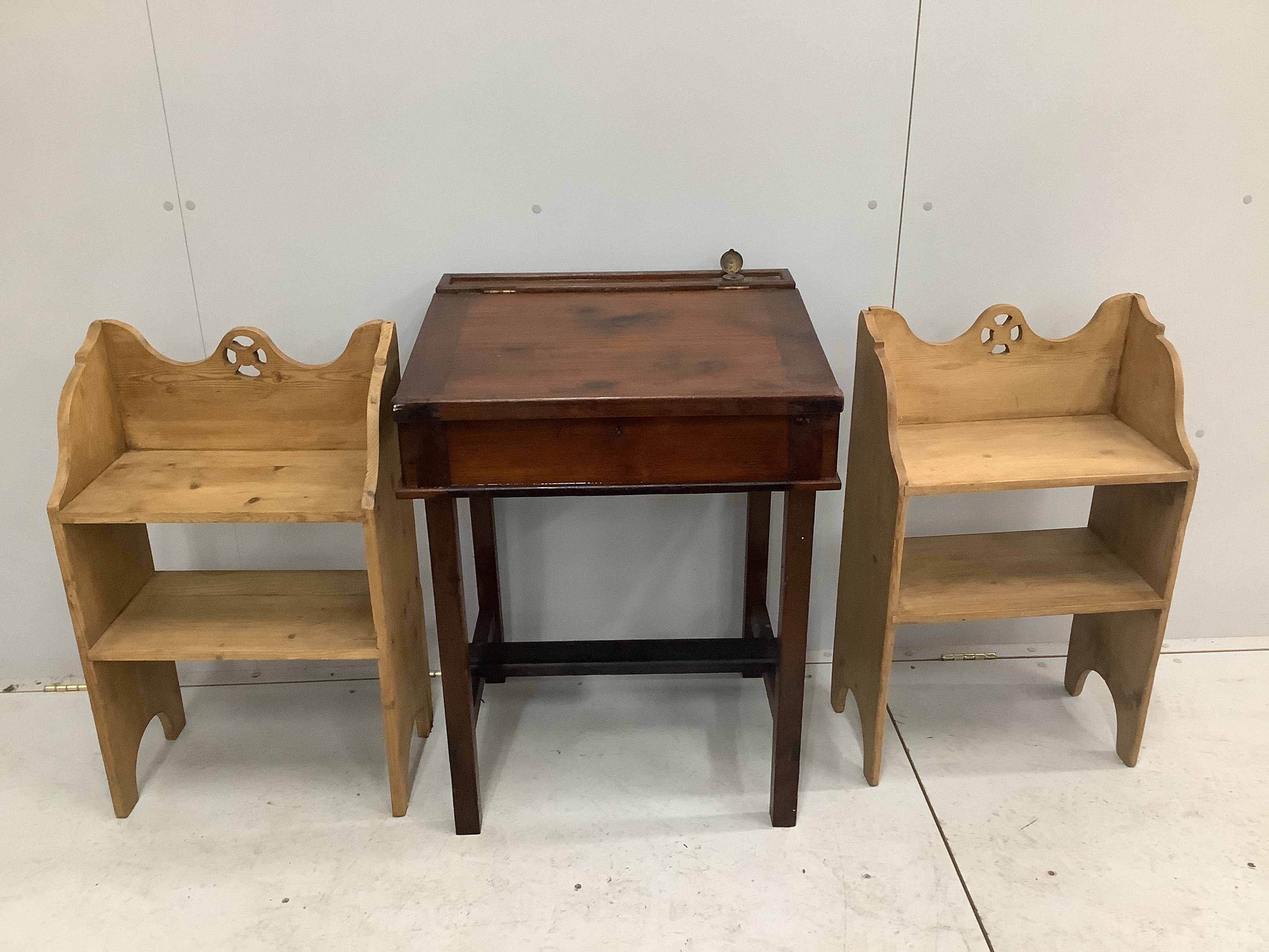 A pair of Gothic style pine two tier bedside tables, width 47cm, depth 24cm, height 76cm, together with a stained wood student's desk
